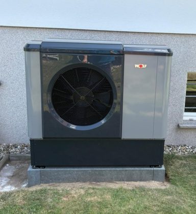 Wärmepumpen-Außengerät mit großem Ventilator an einer Wand.